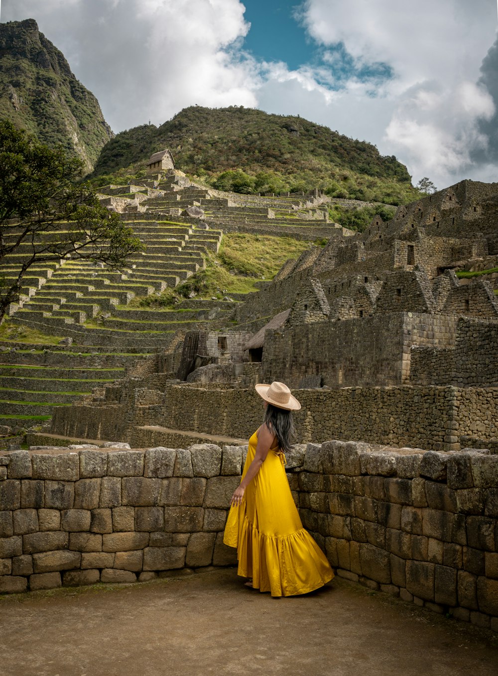 a woman in a yellow dress and a straw hat