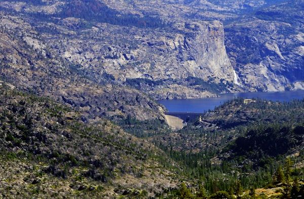 A damned lake is surrounded by mountains. 