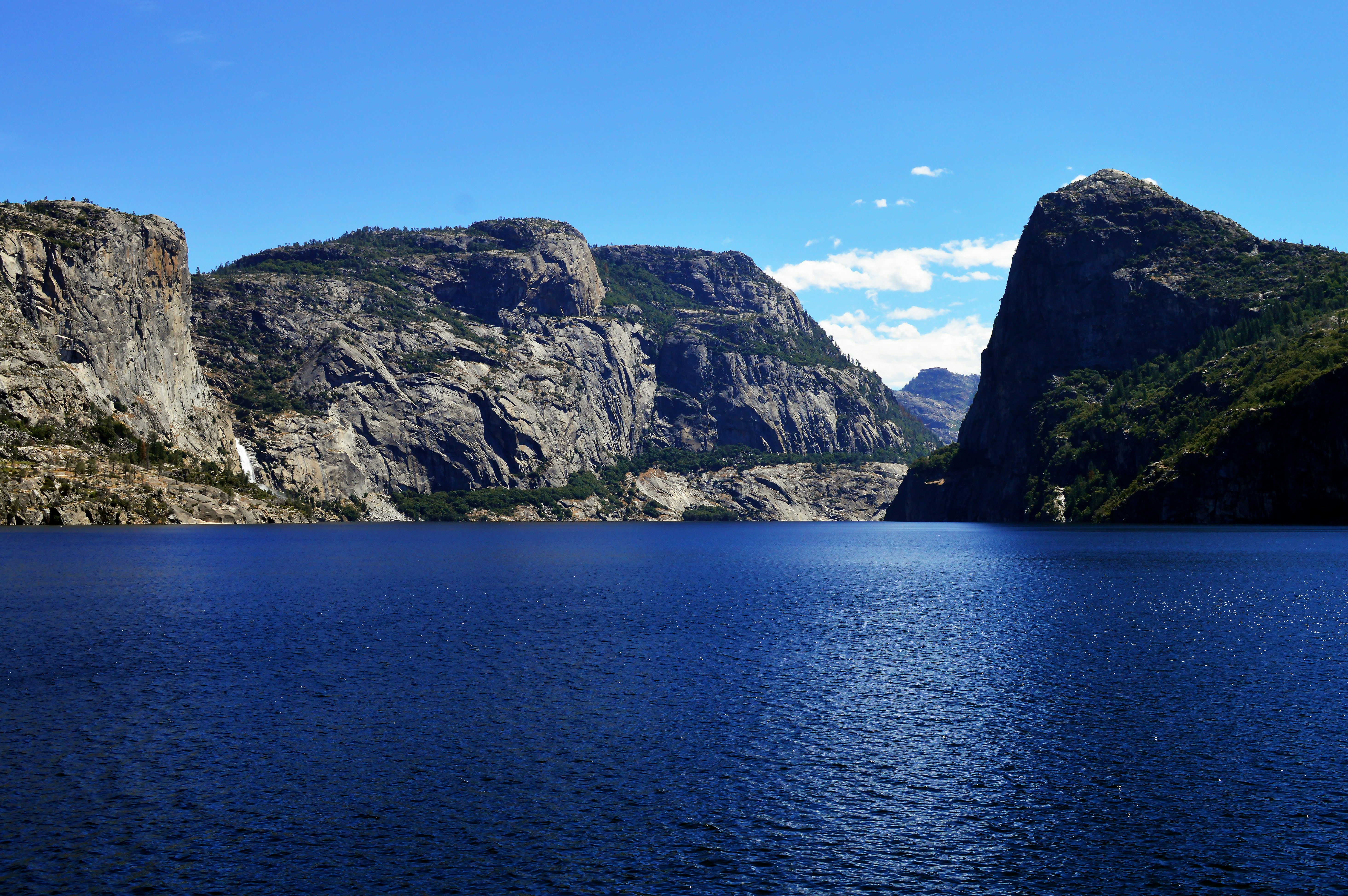 a large body of water surrounded by mountains, Hetch Hetchy Yosemite National Park Service</p><p>Hidden in Yosemite National Park’s peaceful northwest corner, Hetch Hetchy Valley is a treasure worth visiting in all seasons. Located at 3,900 feet, Hetch Hetchy boasts one of the longest hiking seasons in the park and is an ideal place for thundering spring waterfalls and wildflower displays. High temperatures prevail in summer months, but that is a small price to pay for the reward of vast wilderness filled with stunning peaks, hidden canyons, and remote lakes.