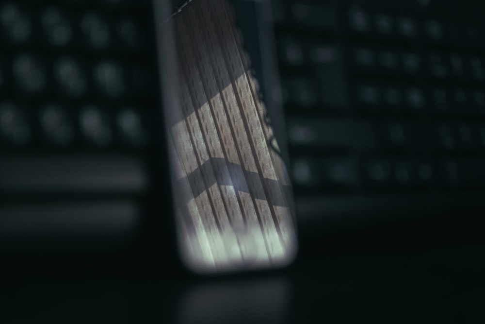 a close up of a cell phone near a keyboard