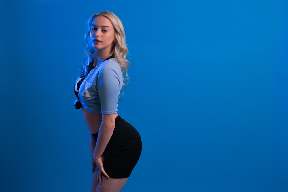 a woman posing for a picture with a blue background