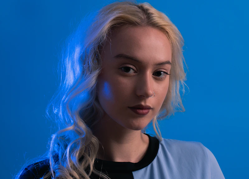 femme blonde devant un fond bleu élégant
