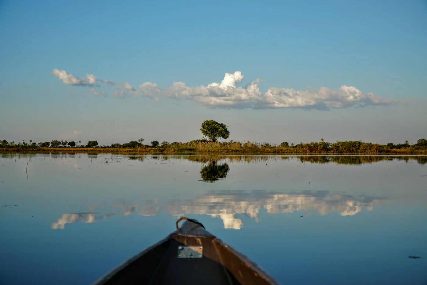 Mokoro bow reflected in a calm lagoon
