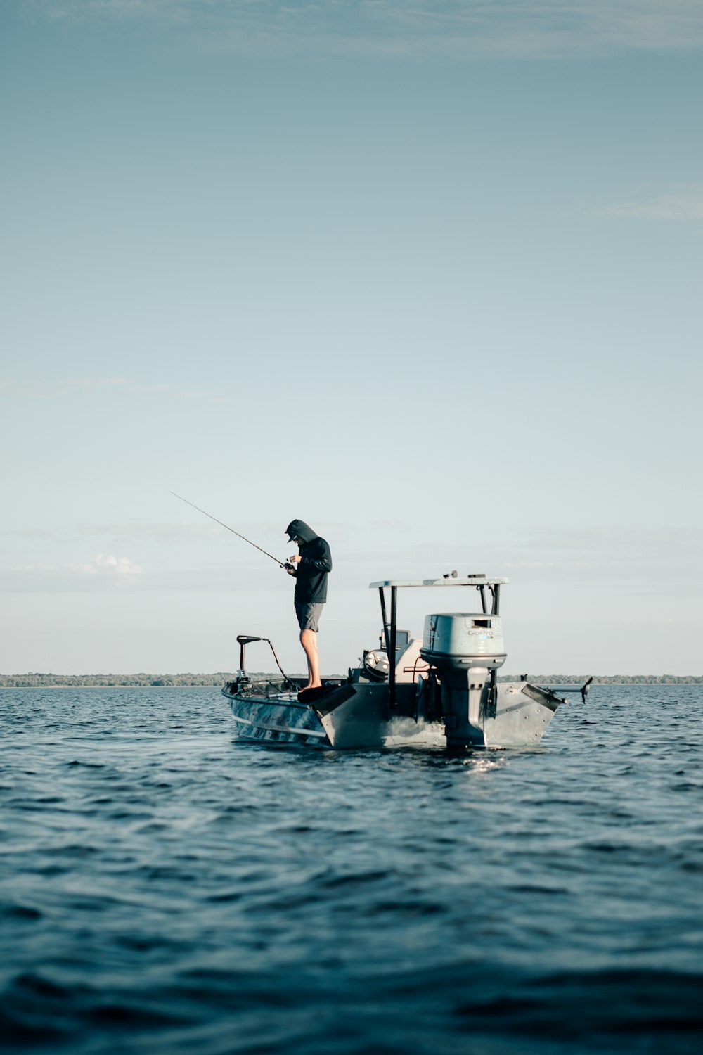 a man standing on top of a boat while fishing