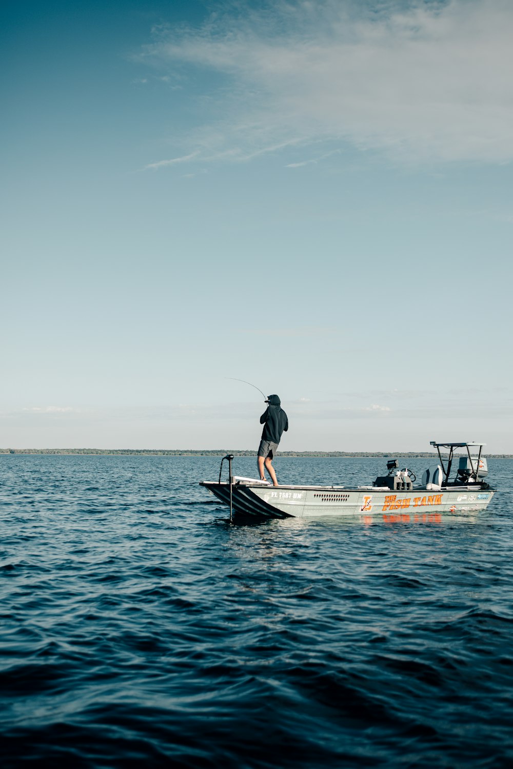 a man standing on a boat in the middle of the ocean