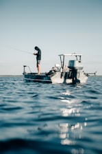 a man fishing on a small boat in the ocean