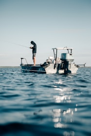 a man fishing on a small boat in the ocean