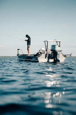 a man fishing on a small boat in the ocean