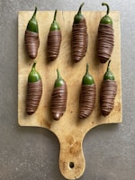 Spicy chili-coated gummy candies arranged on a rustic wooden plate