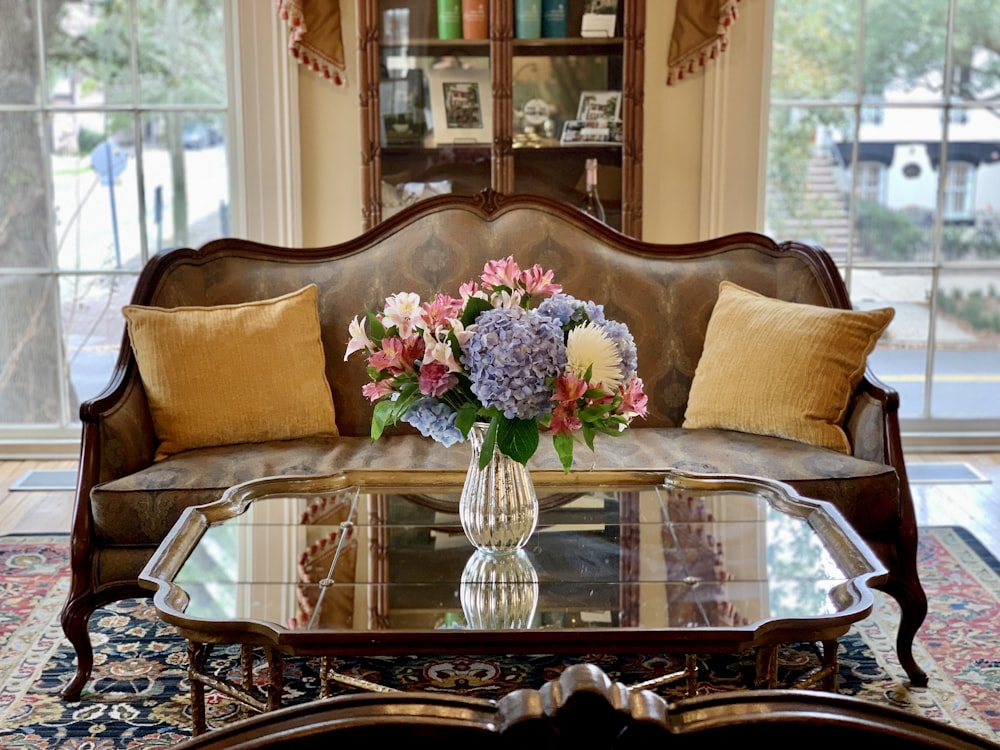 a living room with a couch and a table with flowers on it