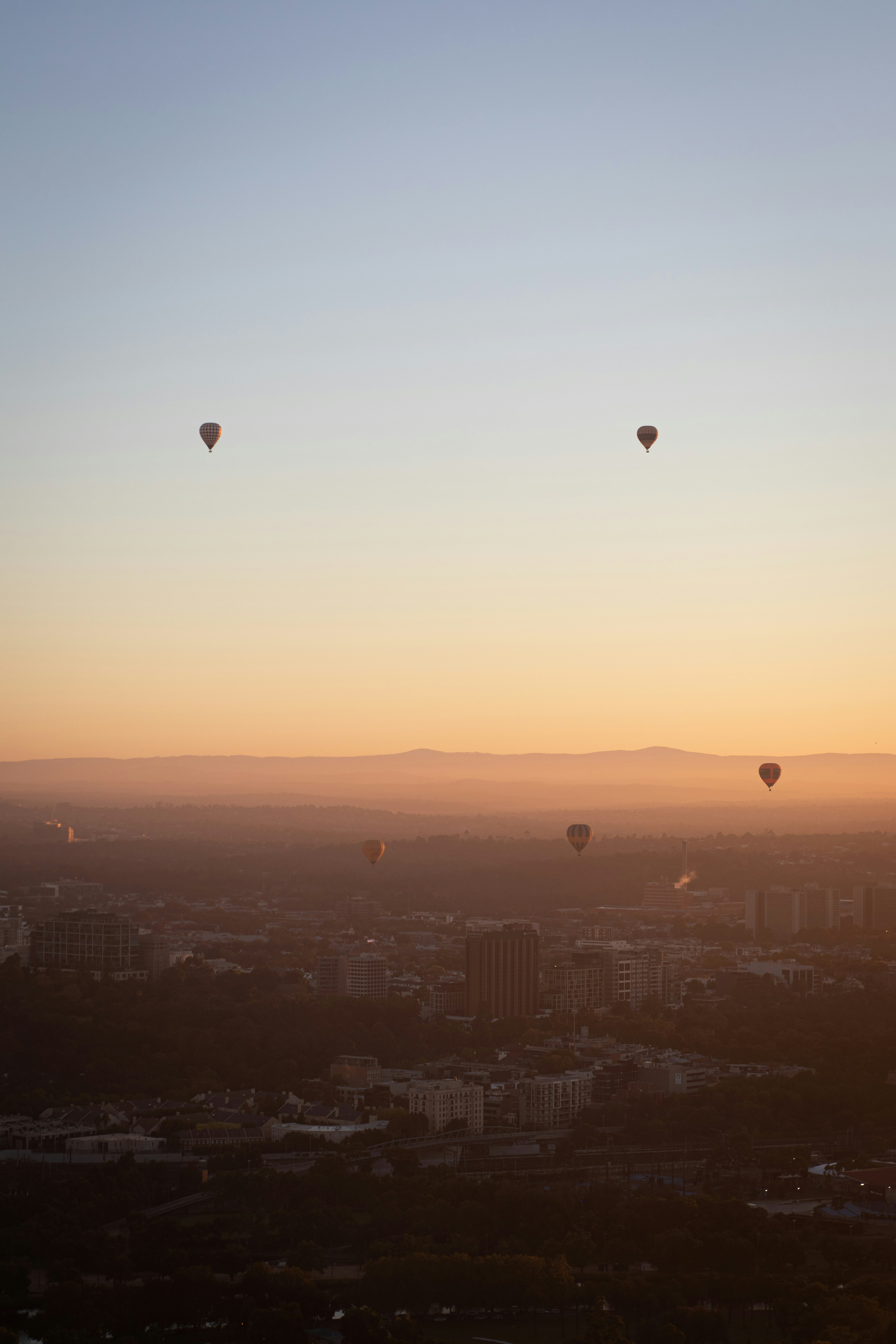 a group of hot air balloons flying over a city