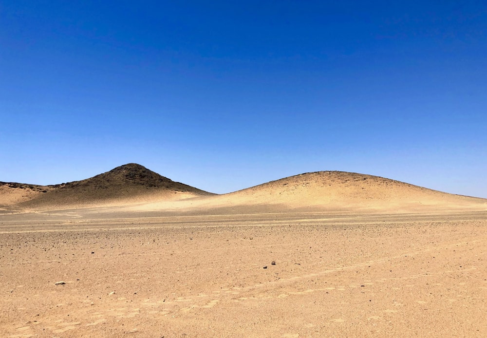 a couple of hills sitting in the middle of a desert