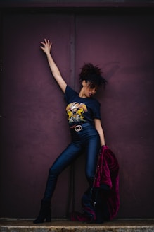 a woman leaning against a purple wall Agencia La Movida Marca Personal