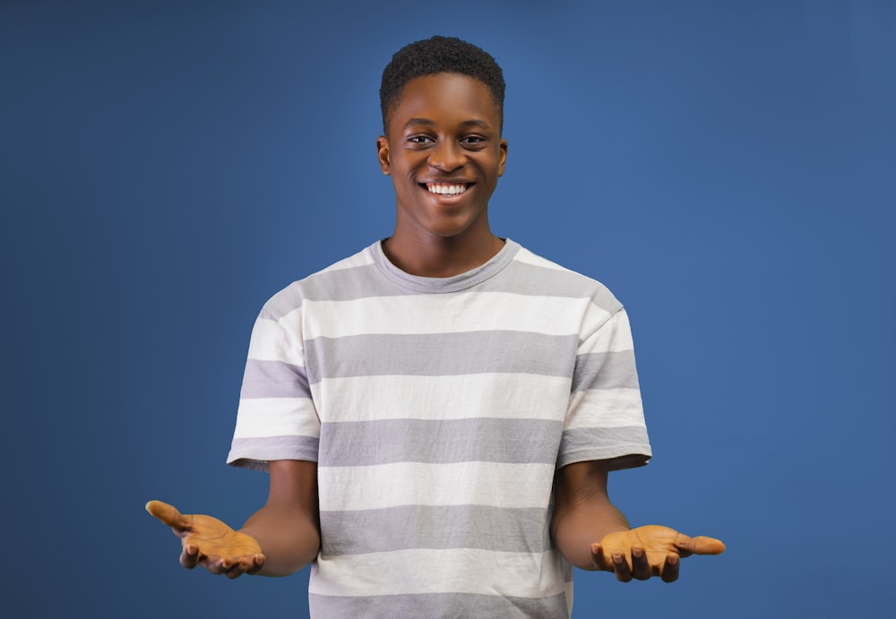 a young man is smiling and holding out his hands