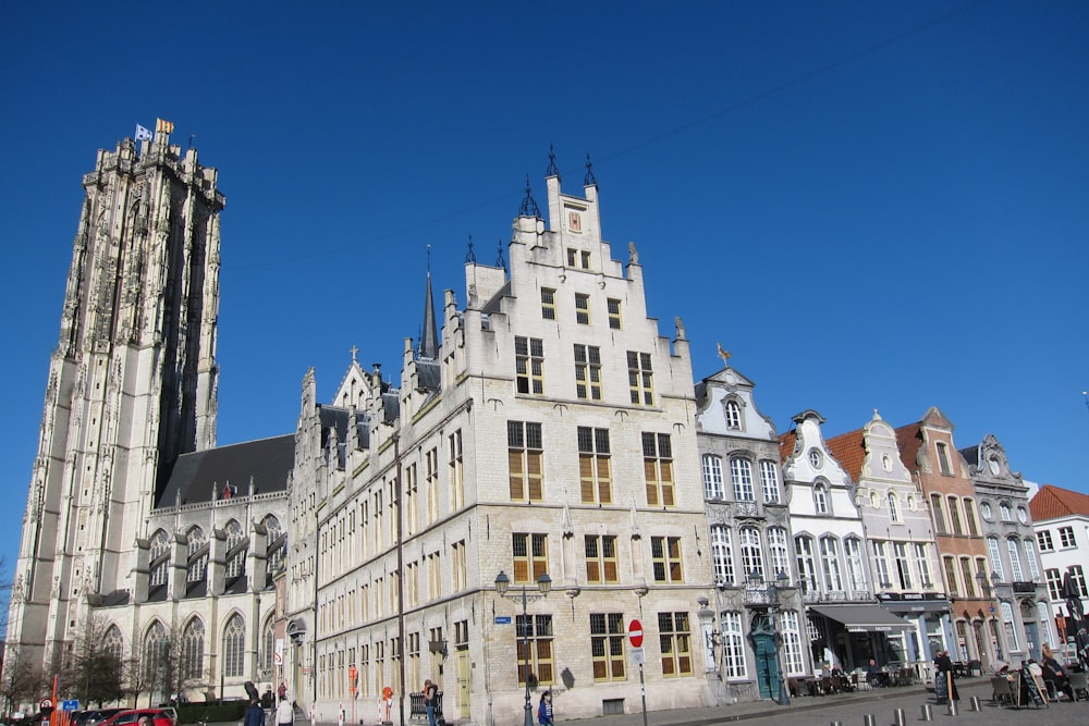 a large building with a tall tower next to other buildings