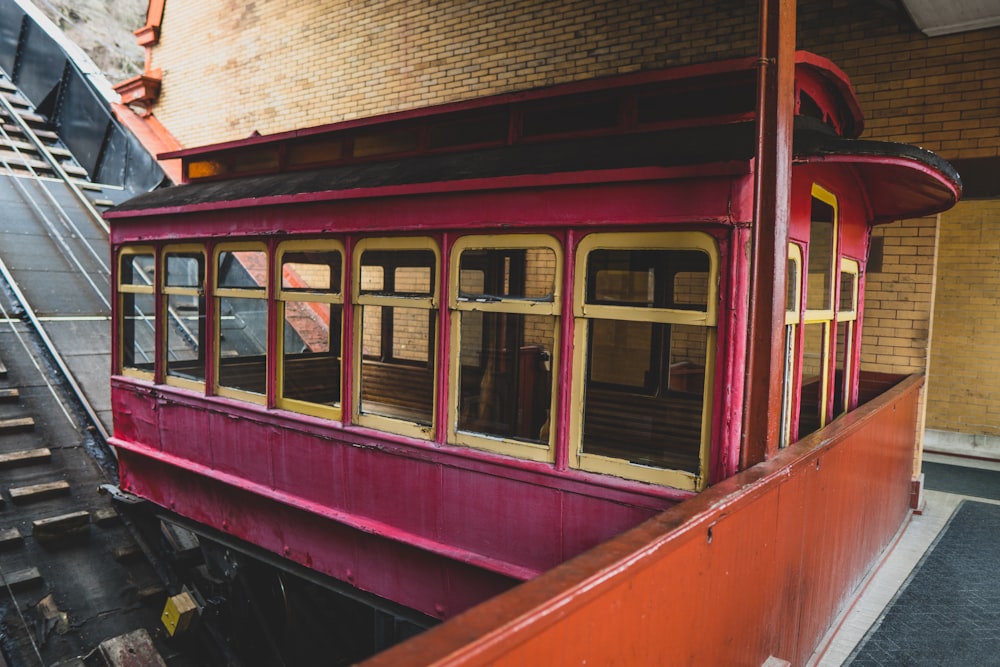 a red train car sitting in a train station