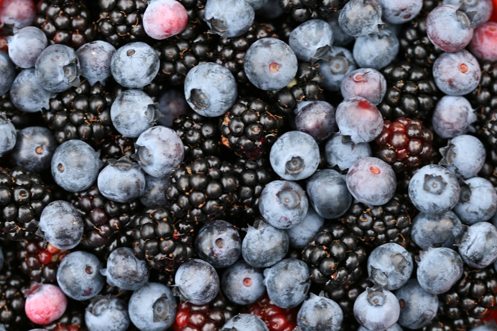 a bunch of blueberries and raspberries in a bowl