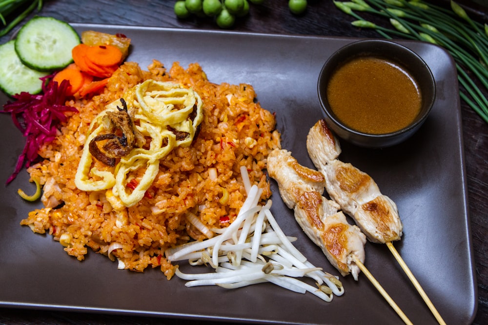 a plate of food with chicken, rice and vegetables