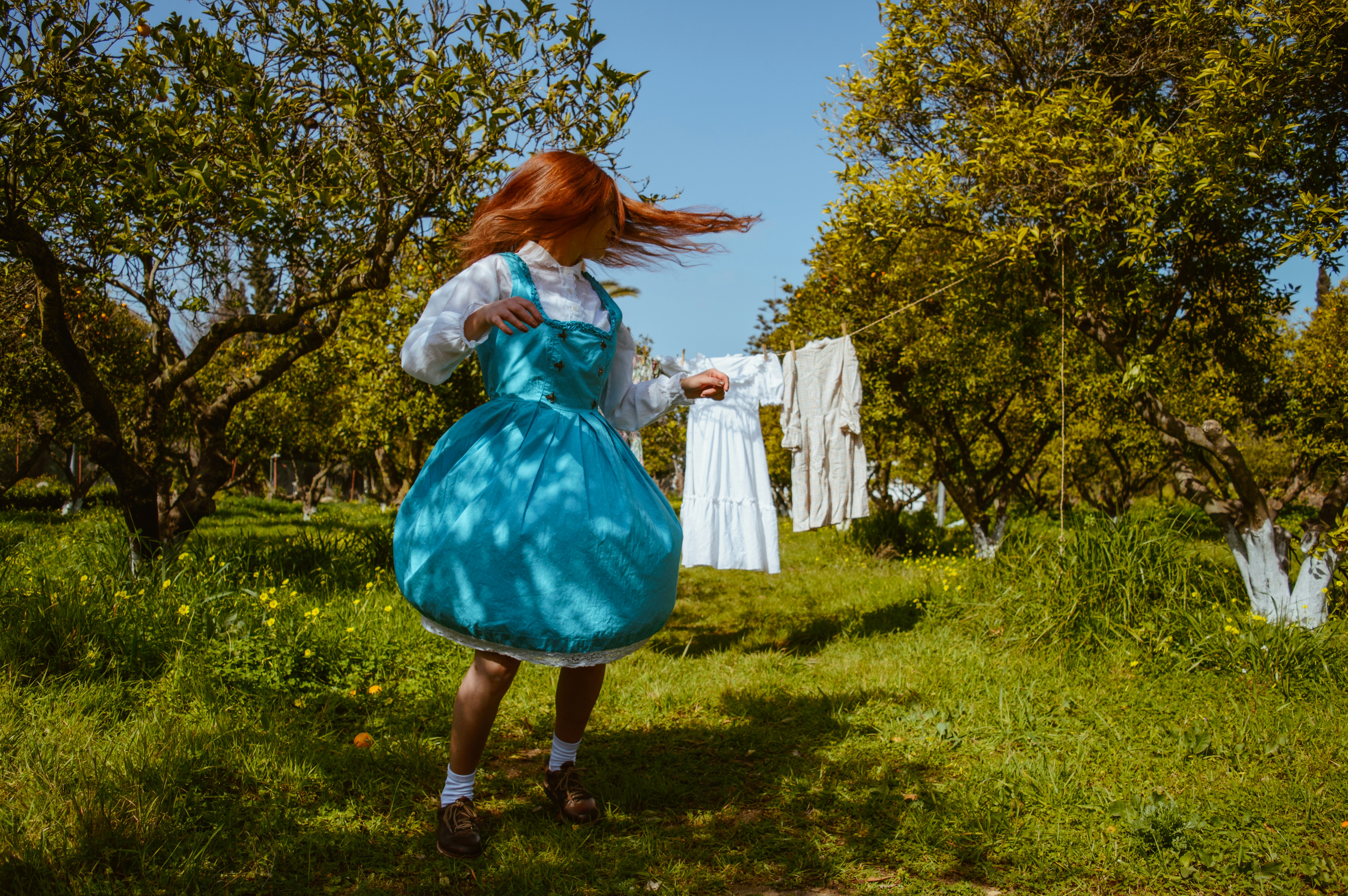 A little girl in a blue dress standing in the grass photo – Free Human ...