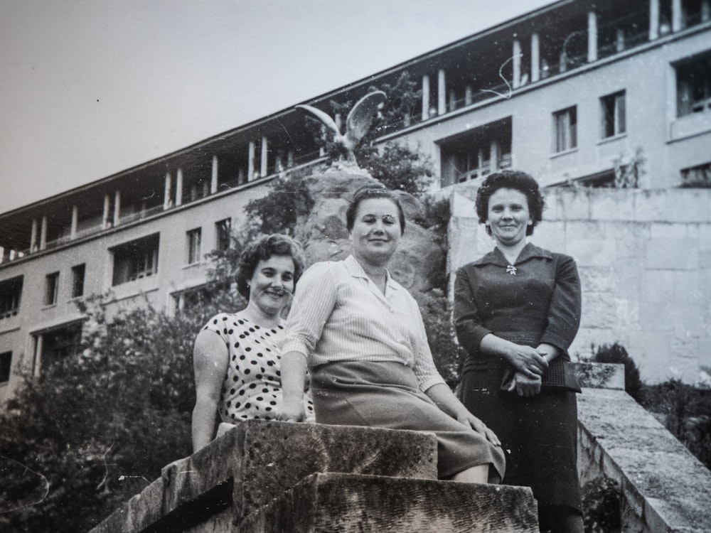 Un grupo de mujeres de pie una al lado de la otra frente a un edificio