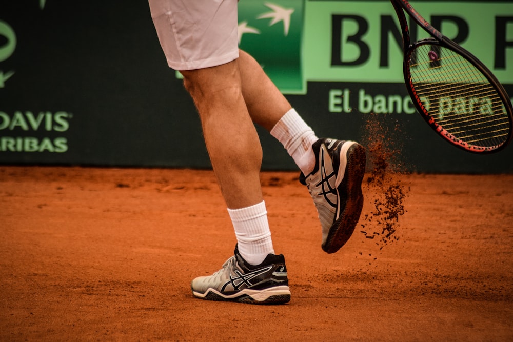 Un jugador de tenis con una raqueta de tenis en la mano