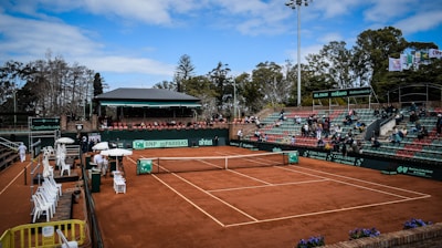 a tennis court with a crowd of people watching it