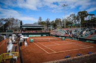 Spectators cheering from the sidelines, enjoying the lively tennis competition atmosphere.