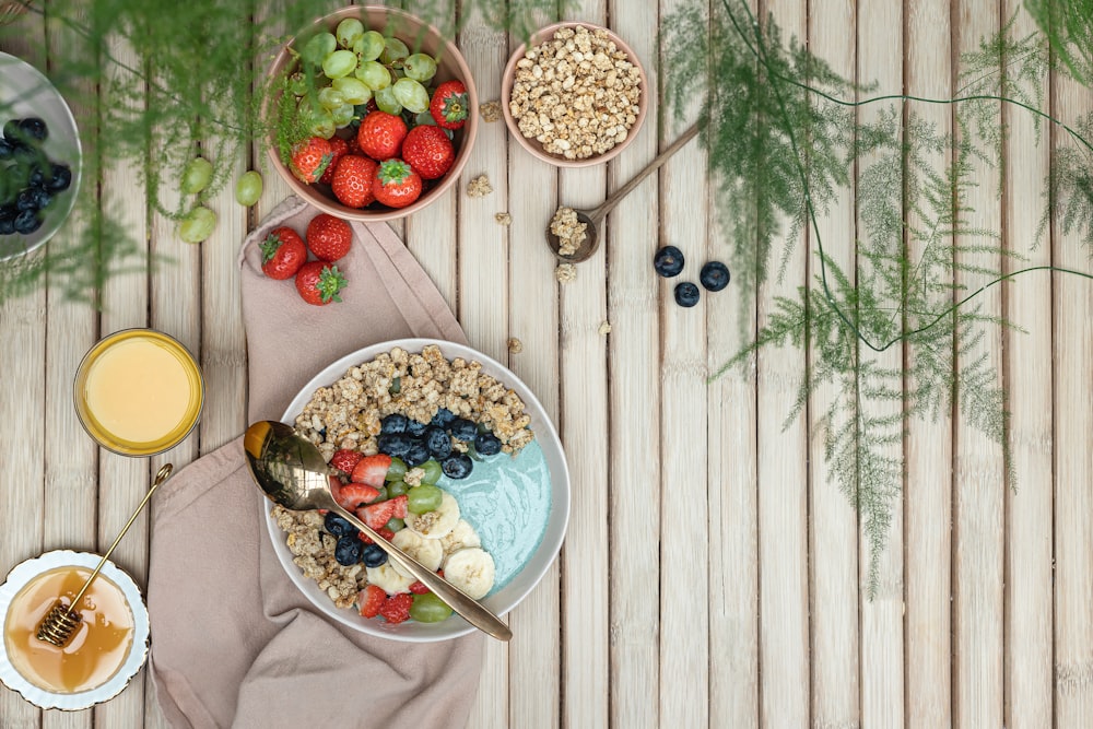 a table topped with bowls of fruit and cereal