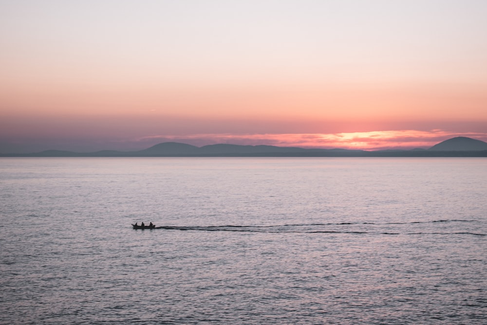 a small boat in the middle of a large body of water