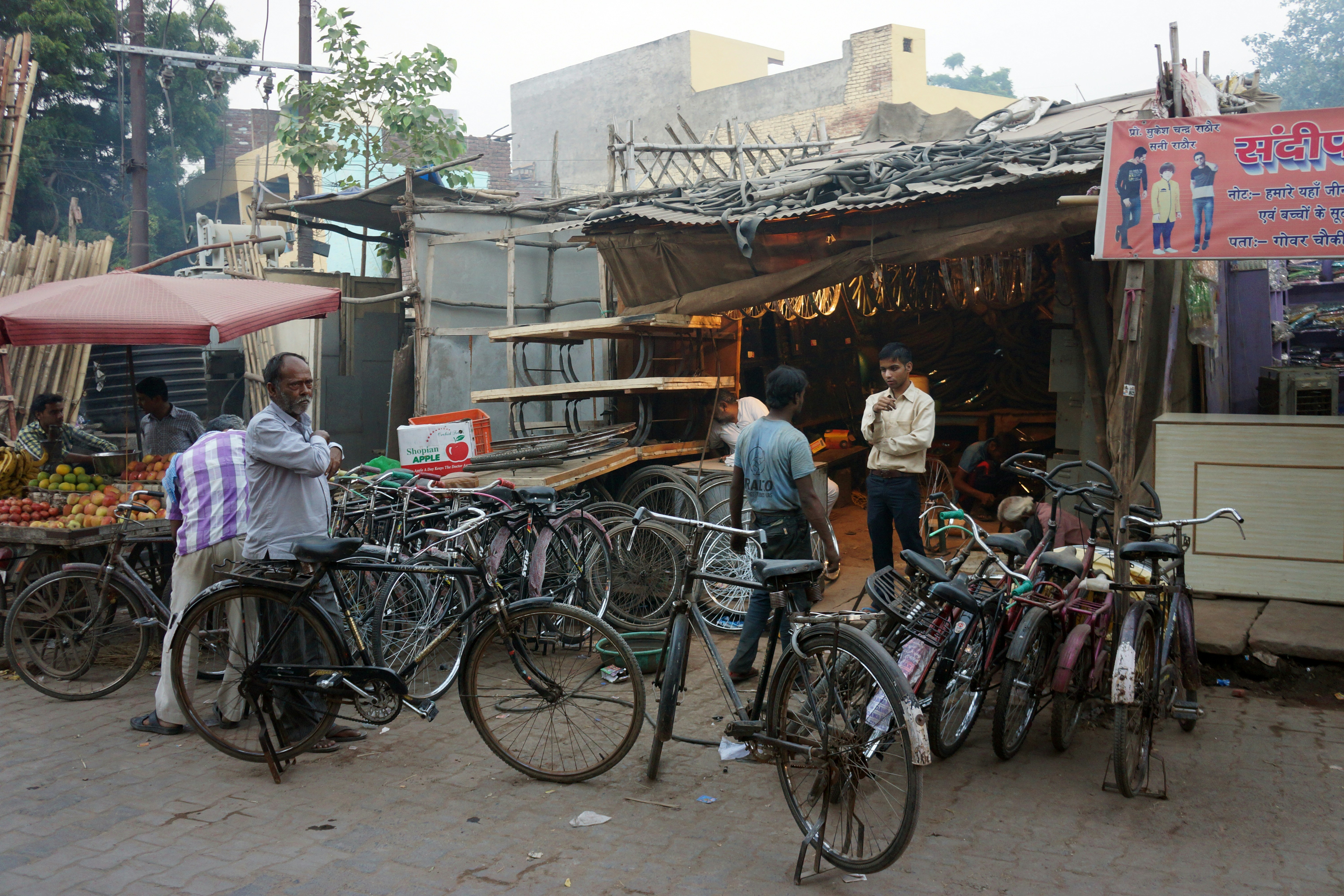 a group of people standing around a bunch of bikes