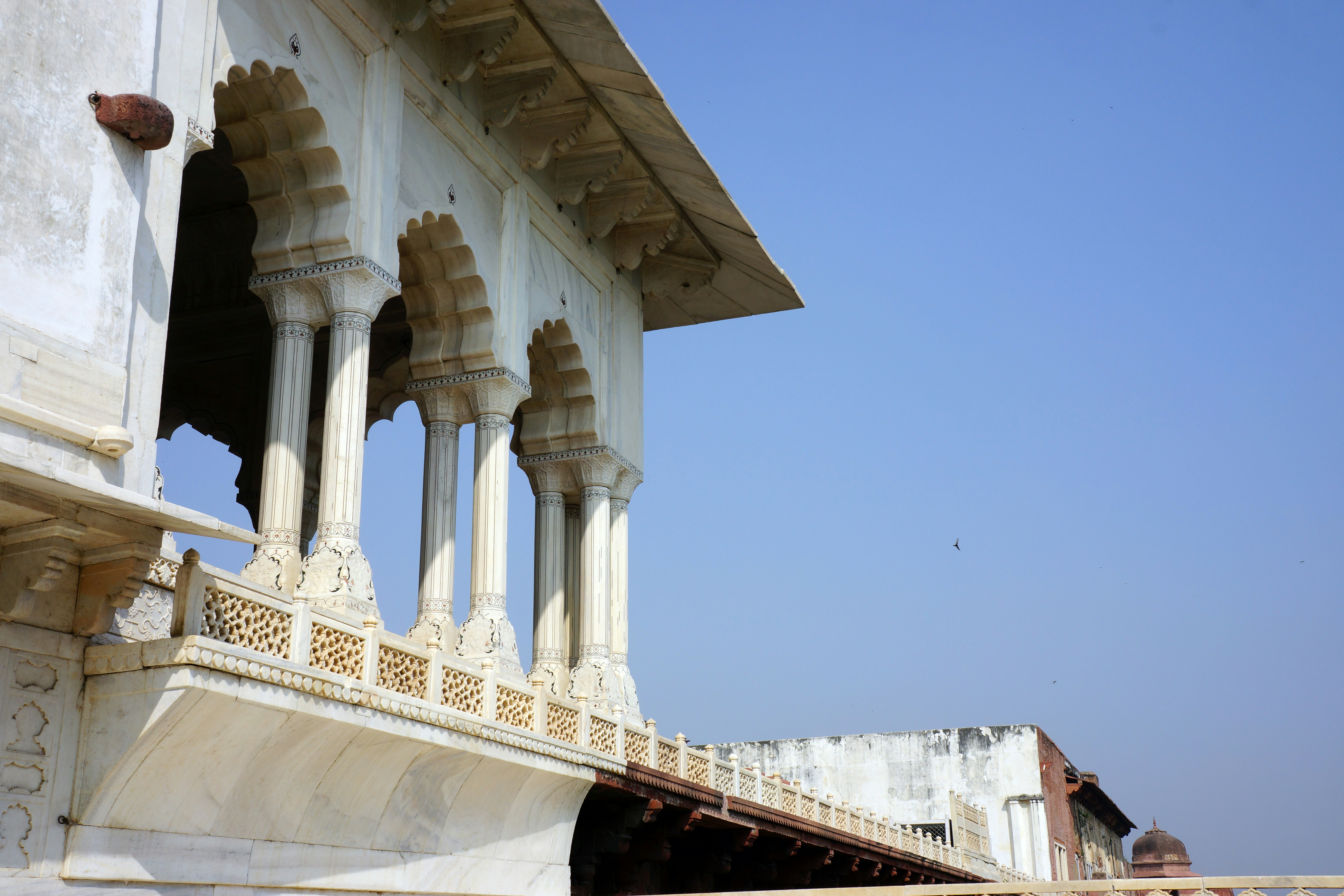 a white building with pillars and a sky background