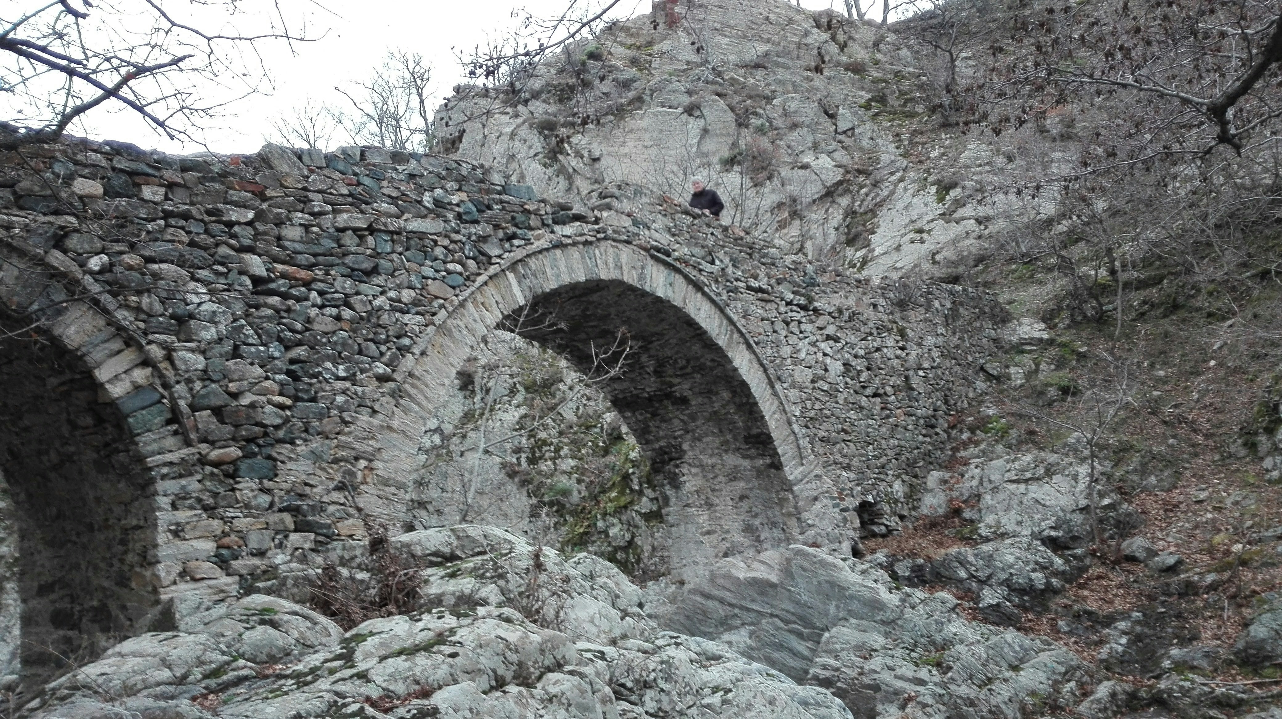 a stone bridge with a bird perched on top of it