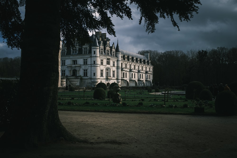 a large white building sitting next to a lush green park