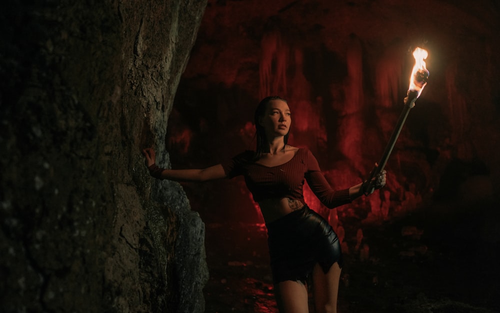 a woman holding a torch in a cave