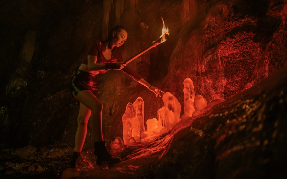 a woman holding a stick in a cave