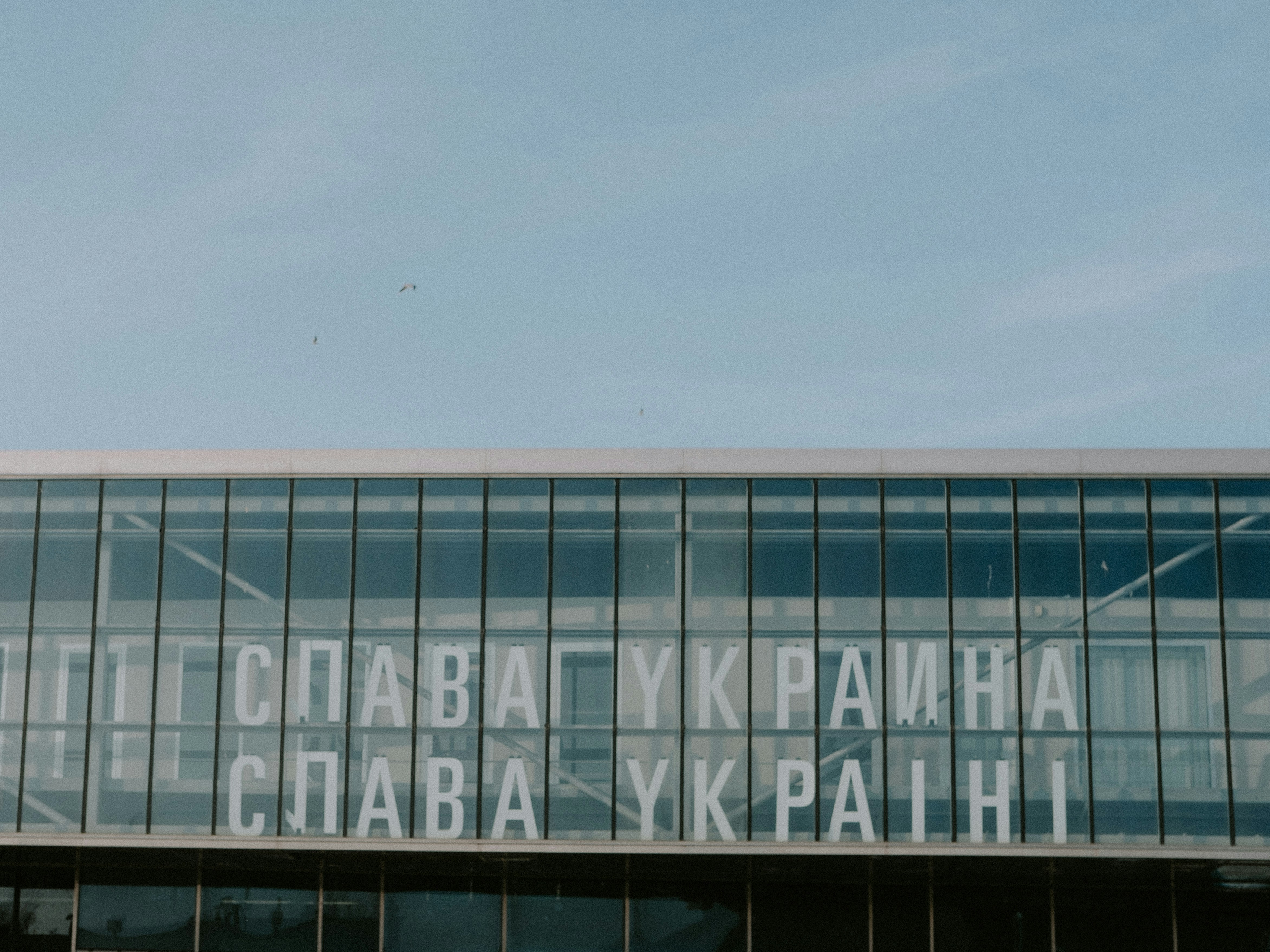 a large glass building with a sky background