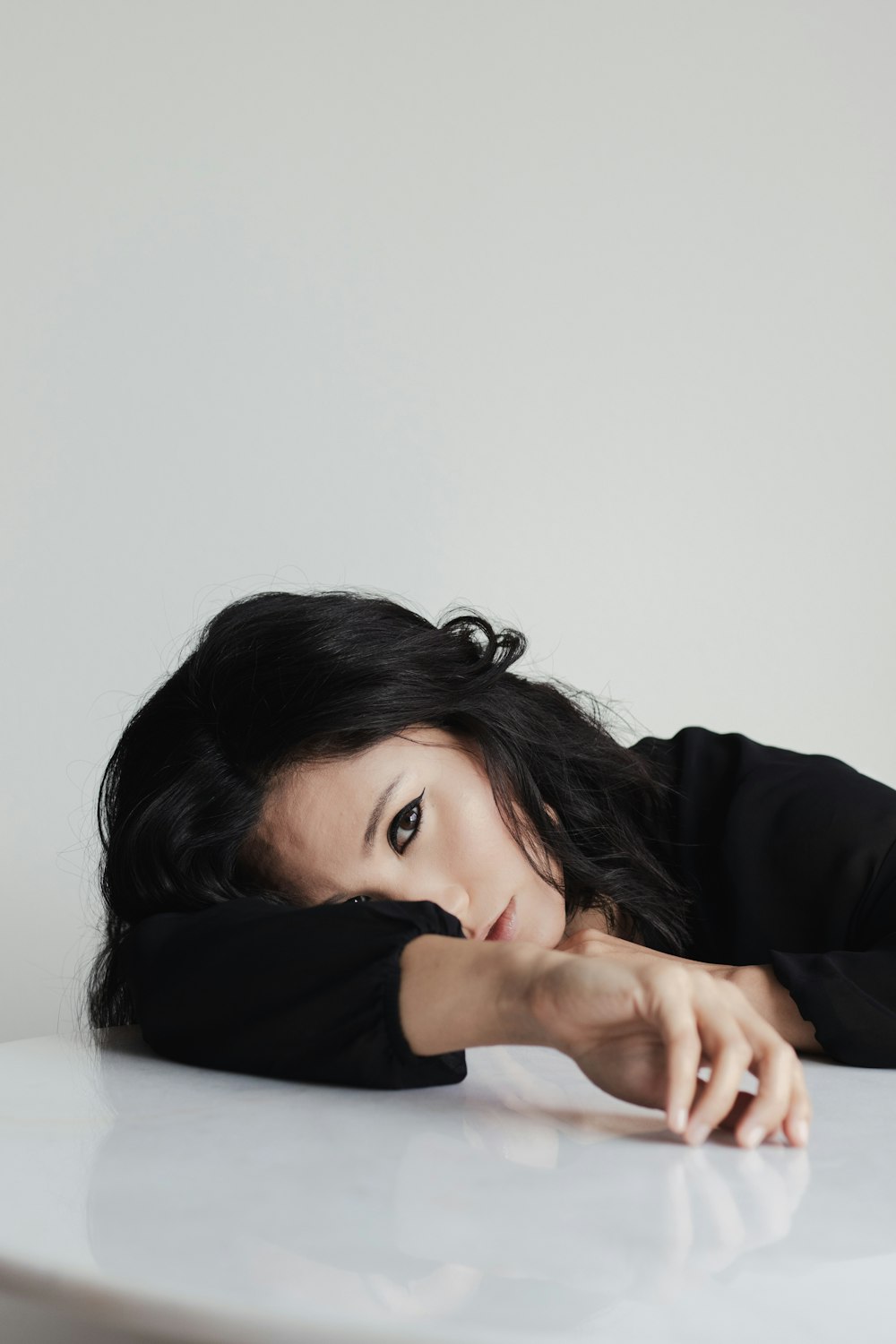 a woman laying on top of a white table