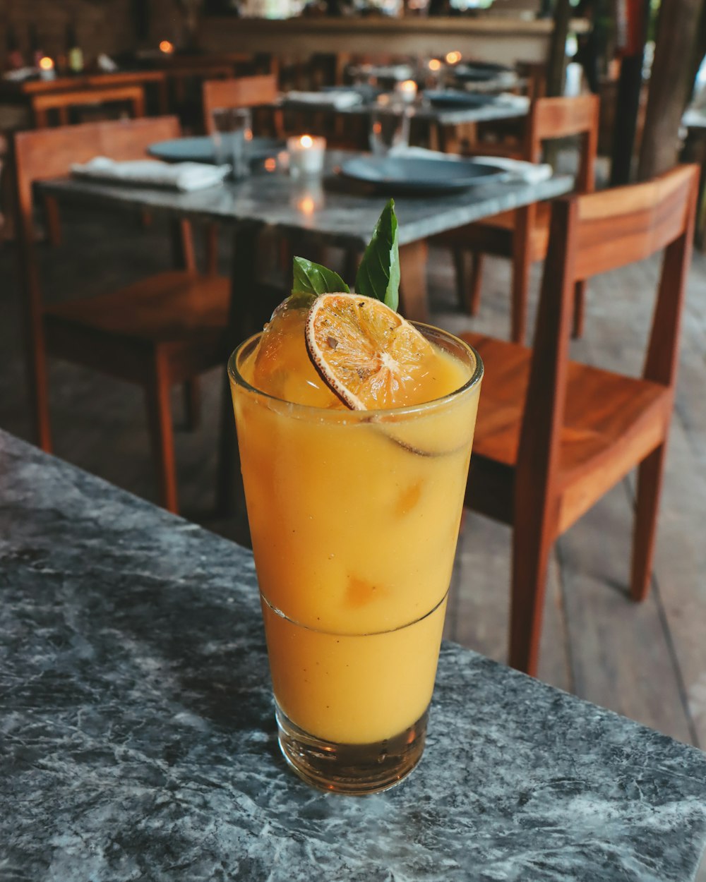 a glass of orange juice sitting on top of a table