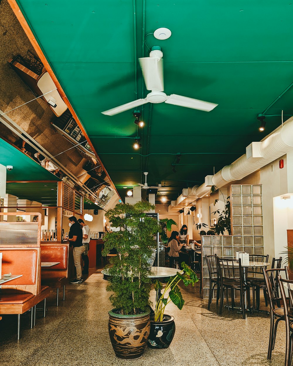 a restaurant with tables and chairs and a ceiling fan