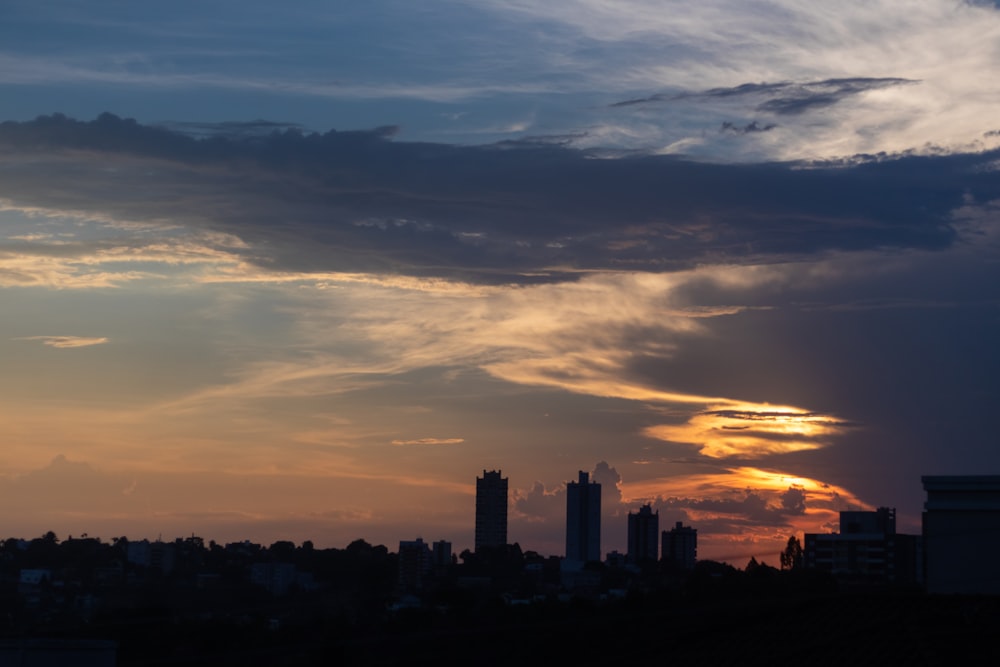 Die Sonne geht über einer Stadt mit hohen Gebäuden unter