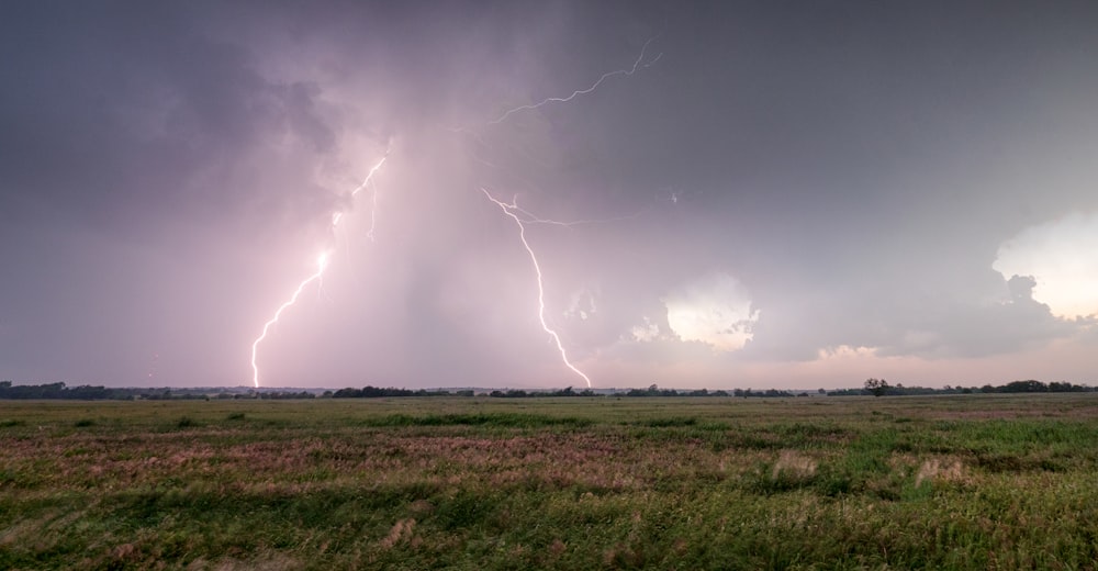 a large field with a lightning bolt in the sky