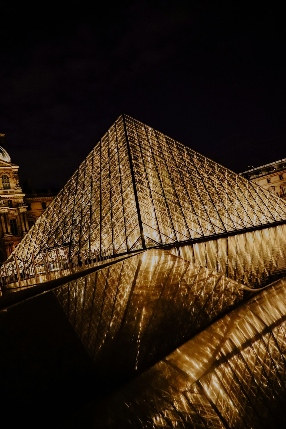 a large glass pyramid in front of a building