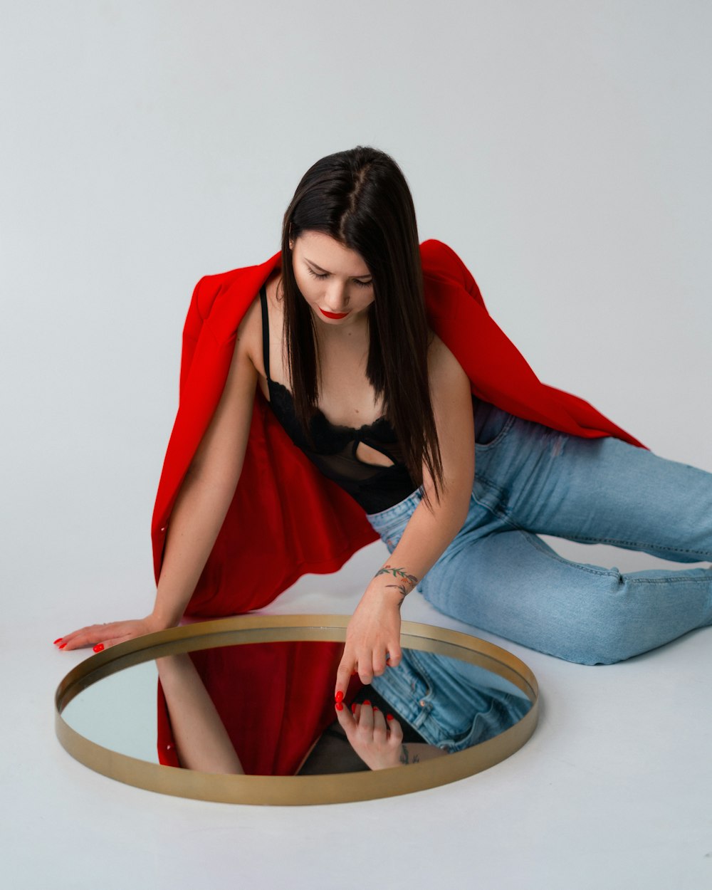 a woman sitting on the floor in front of a mirror