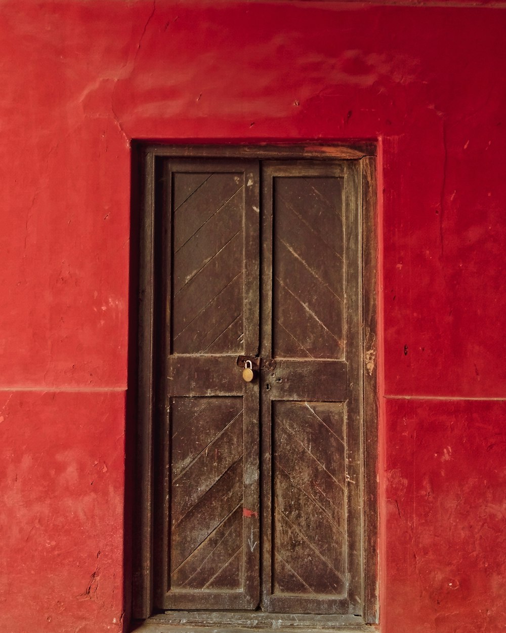a red wall with a wooden door and window