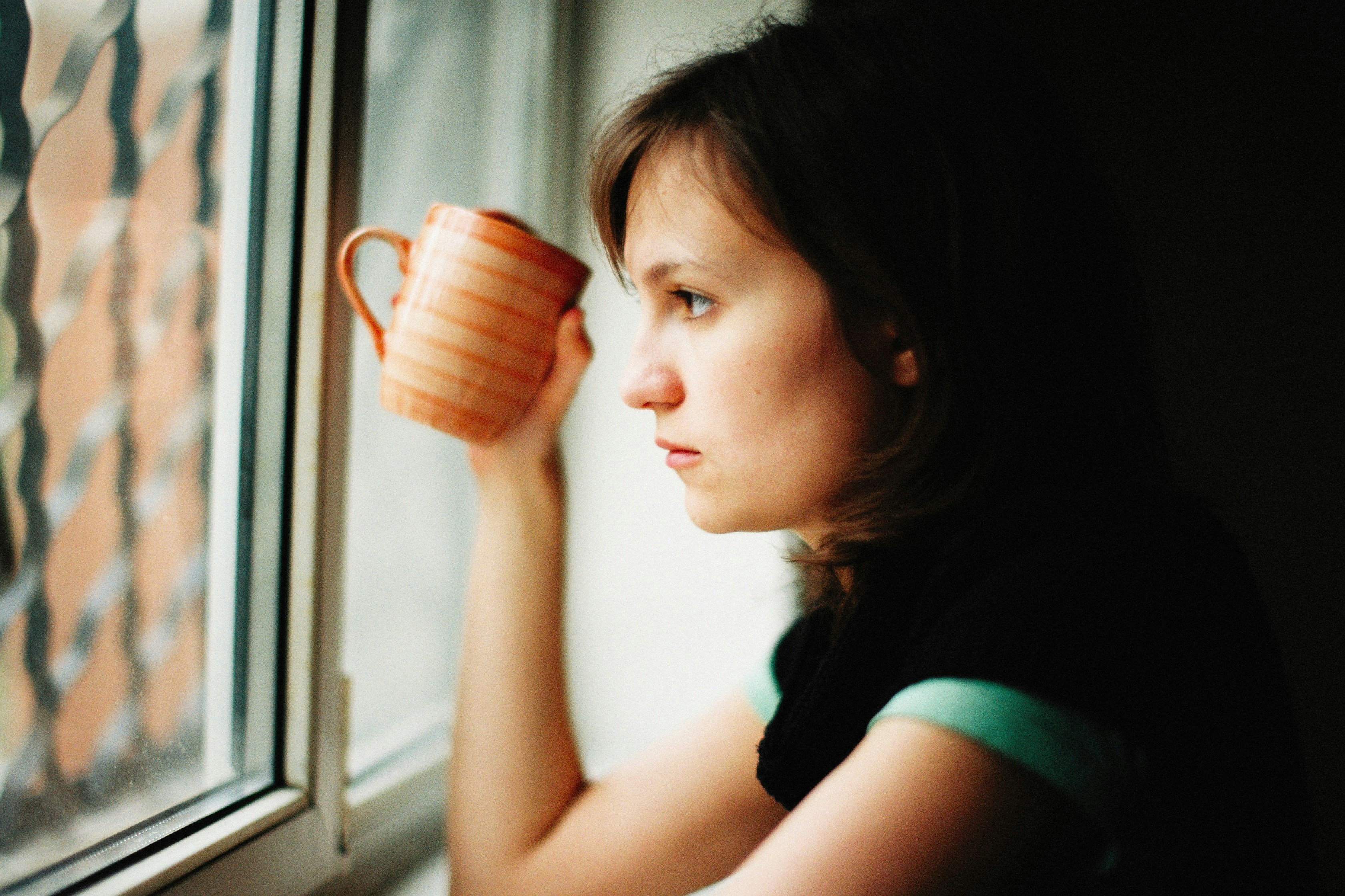 A caregiver looking out a window, taking a quiet moment for reflection and self-care. - support for dementia caregivers