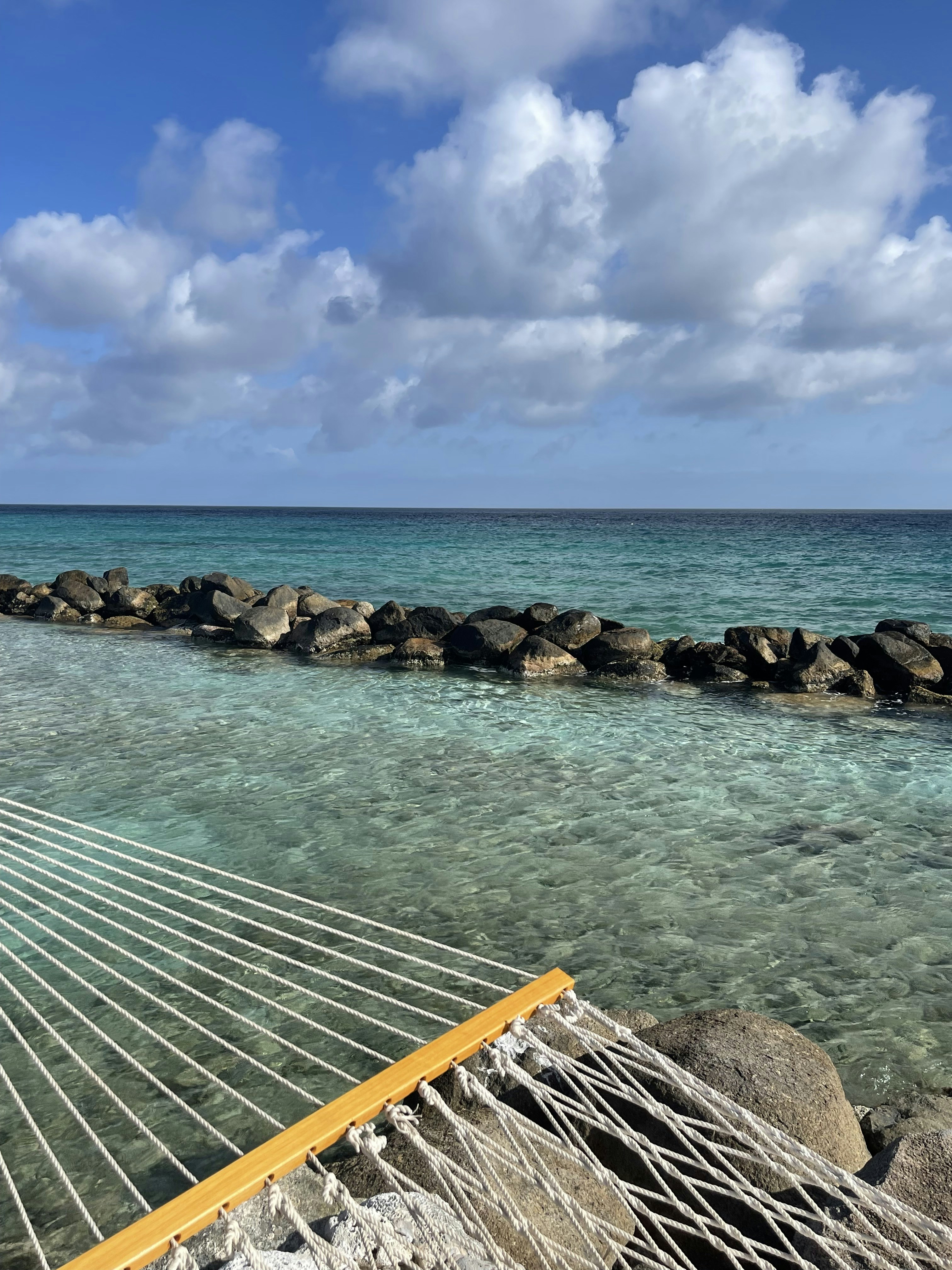 a hammock sitting on the beach next to the ocean
