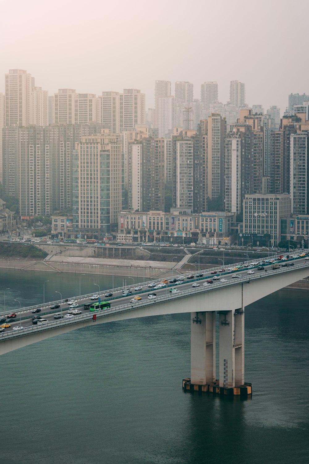 a bridge over a body of water with a city in the background