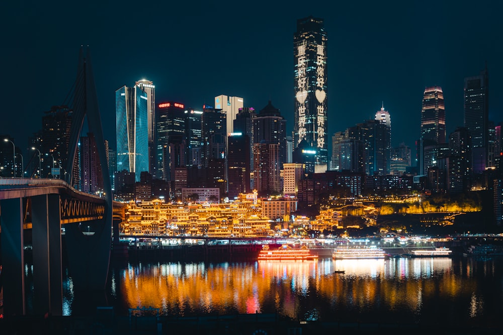 a city skyline at night with lights reflecting in the water