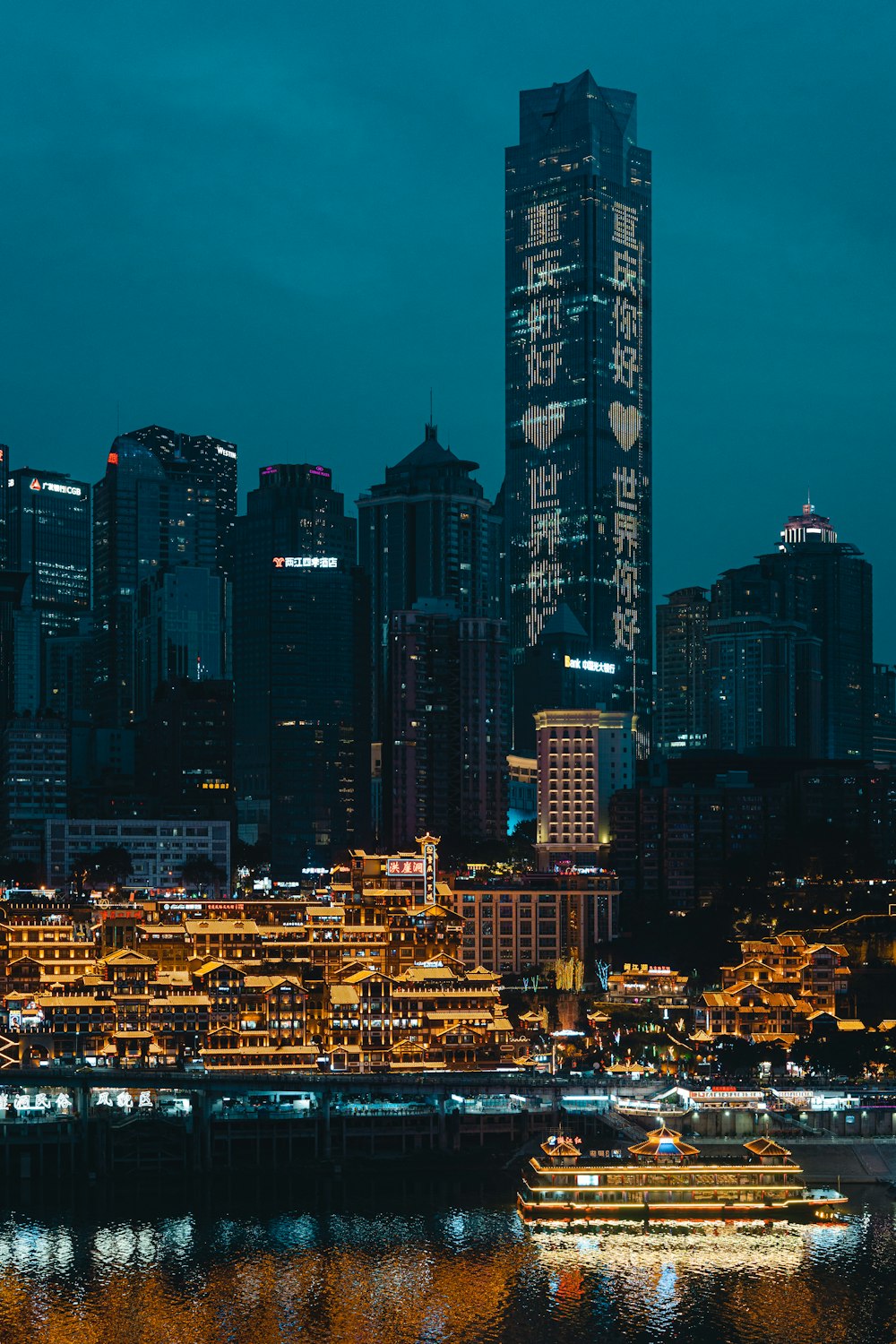 a city skyline at night with a boat in the water