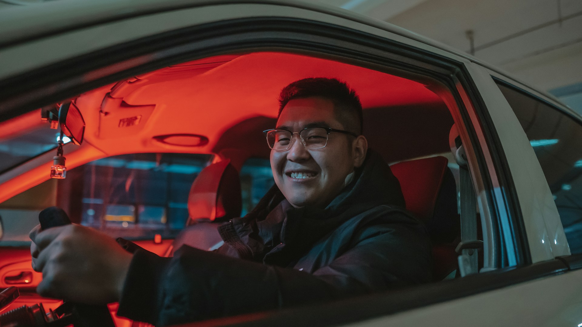 a man driving a car with a red light on